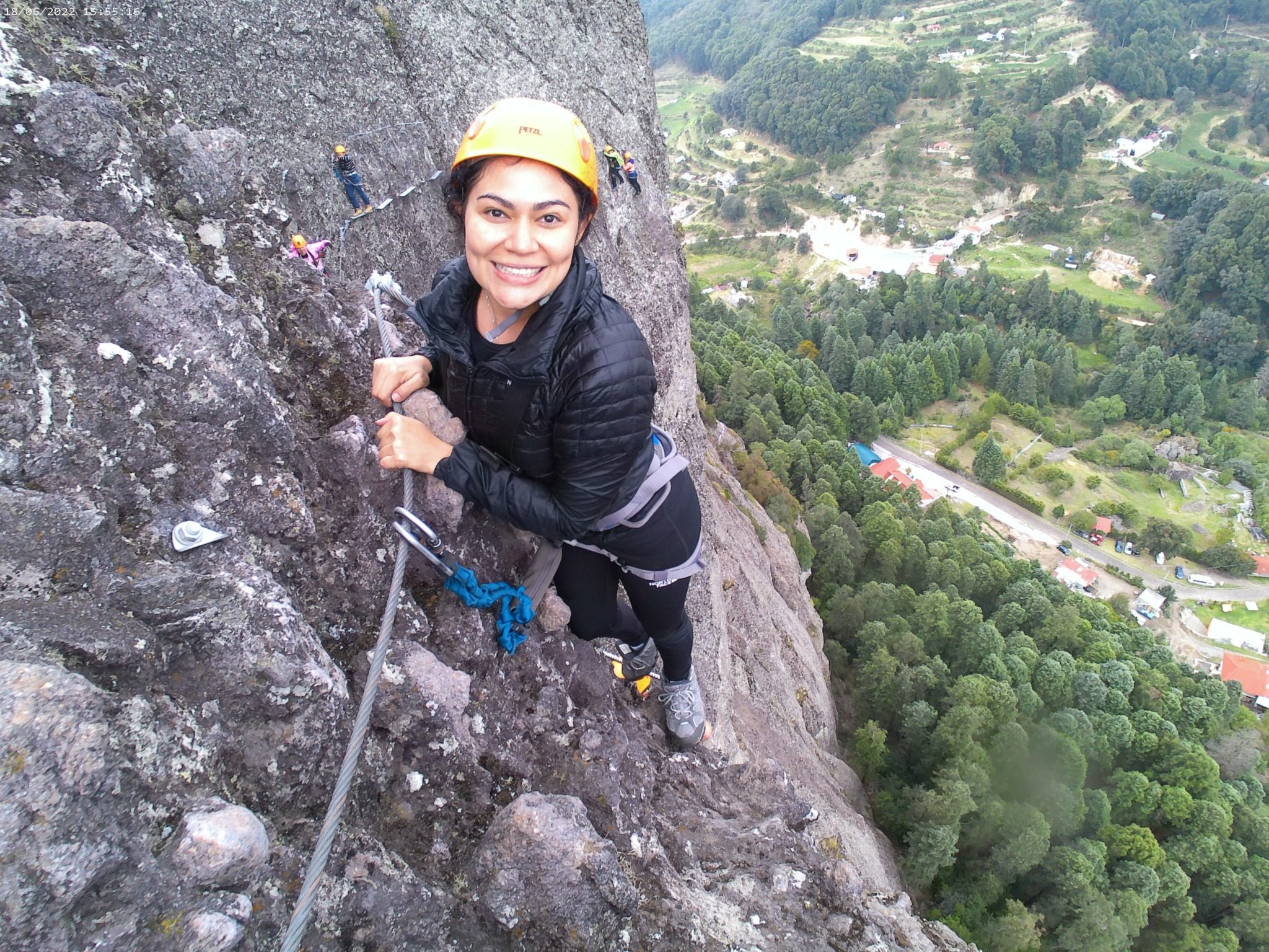 Corina climbing a via ferrata above a valley