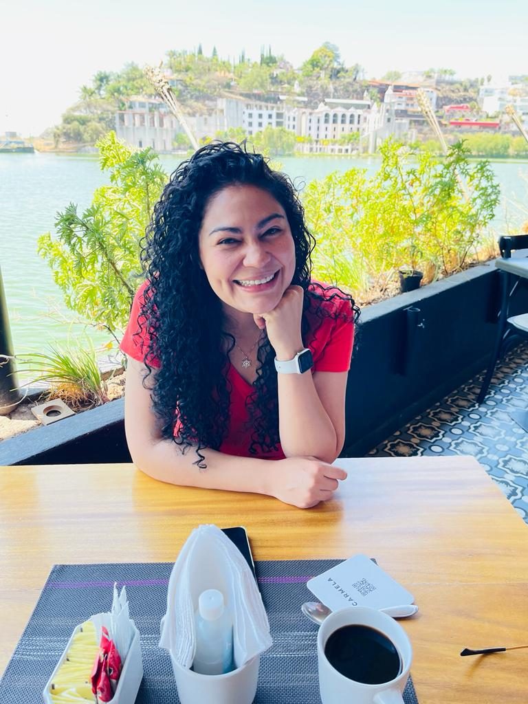 Corina smiling at a lakeside café